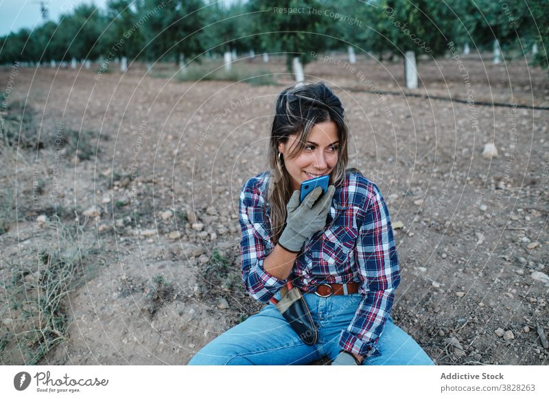 Frau benutzt Smartphone auf dem Bauernhof Landwirt sich[Akk] entspannen Arbeiter Aufzeichnen Audio Stimme Nachricht Telefon Mobile online Browsen Boden