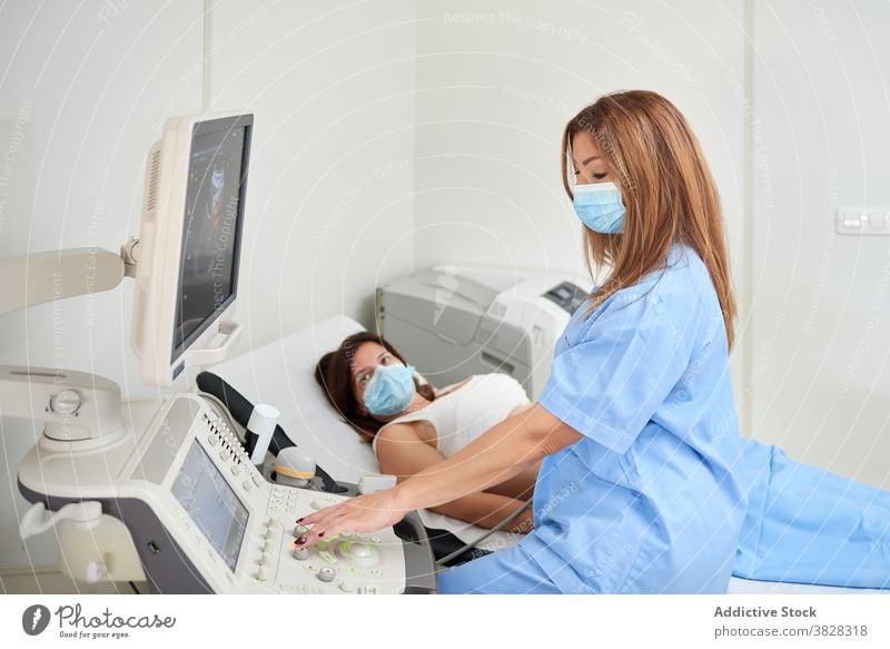 Weiblicher Ultraschalltechniker, der einen Patienten diagnostiziert, während er ein Sonographiegerät benutzt Techniker diagnostizieren geduldig Scanner Monitor