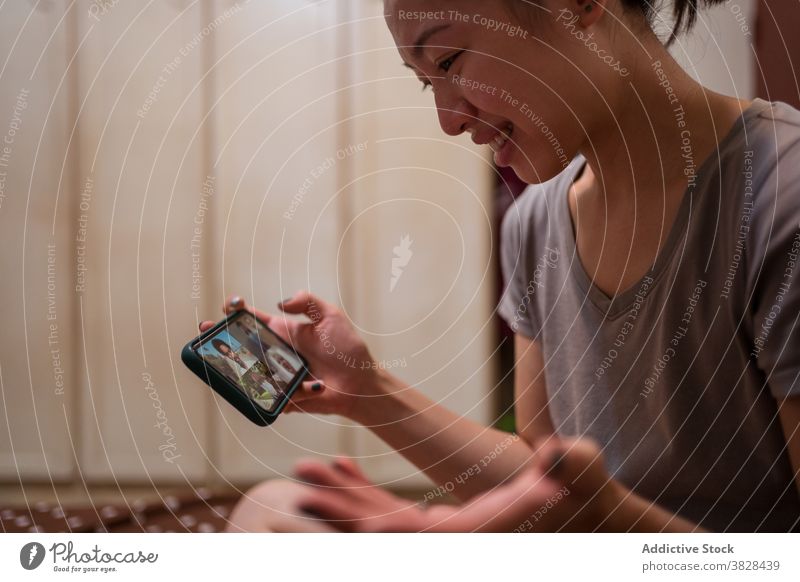 Asiatische Frau macht Videoanruf auf Smartphone zu Hause Coronavirus Selbstisolierung soziale Distanzierung Kommunizieren Video-Chat sitzen online Sitzung