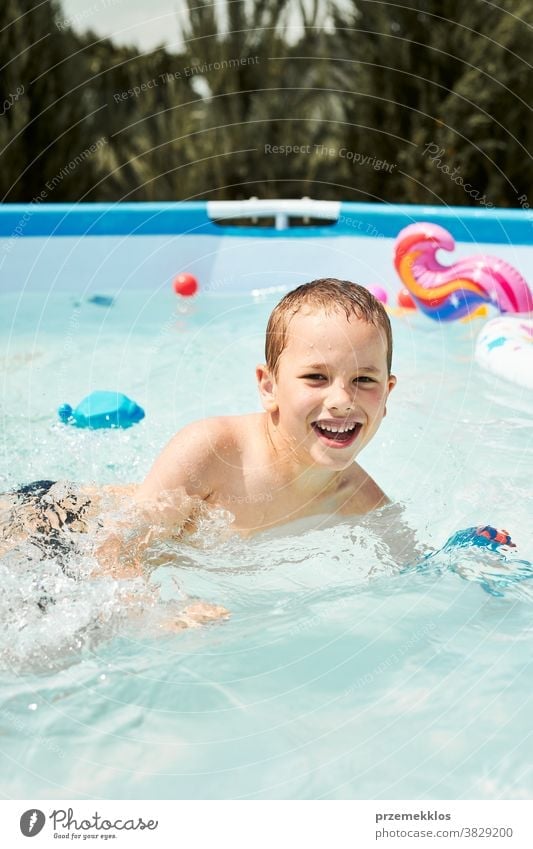 Porträt eines glücklich lächelnden Jungen, der an einem sonnigen Sommertag im Schwimmbad spielt und Spaß hat authentisch Hinterhof Kindheit Kinder Familie