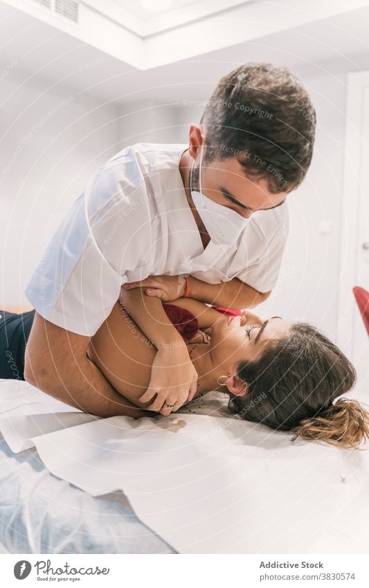 Männlicher Arzt macht rehabilitierende Massage für Patienten Rehabilitation Verfahren Physiotherapie Therapeut anstrengen Schulter Krankenhaus Sitzung