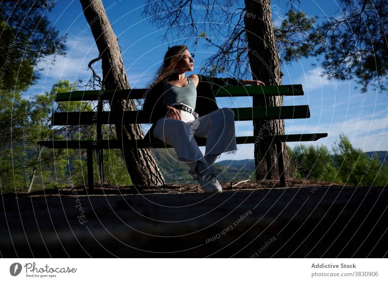 Entspannte Frau, die auf einer Bank im Wald ruht nachdenken sich[Akk] entspannen ruhen Sonnenlicht Natur Wälder Windstille friedlich besinnlich träumen