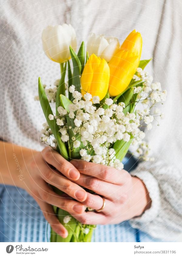 Frau hält Tulpenstrauß. Der Tag der Frau Blumenstrauß Hintergrund Hände Mutter Ostern schön März Haufen Postkarte festlich geblümt Geschenk geben Gruß