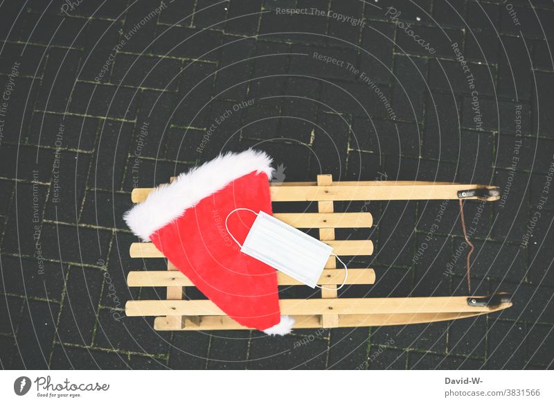 Schlitten mit Nikolausmütze und Atemschutzmaske / Mundschutz Corona Weihnachten pandemie Coronavirus Schützen