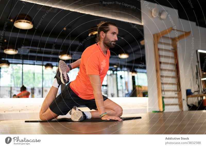 Bärtiger Sportler beim Stretching in der Turnhalle Training Dehnung Fitness Fitnessstudio beweglich modern Stock Gesundheit passen männlich Athlet Erwachsener