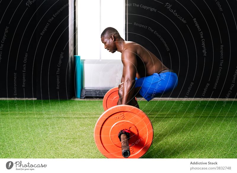 Schwarzer athletischer Mann hebt Langhantel im Fitnessstudio Gewichtheben Curl-Hantel schwer Sportler muskulös Torso Bodybuilder stark männlich ethnisch schwarz