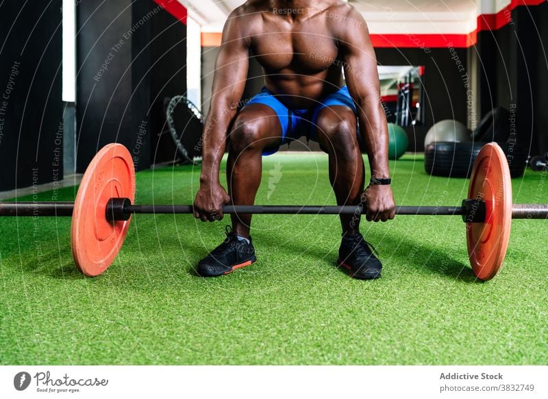 Schwarzer athletischer Mann hebt Langhantel im Fitnessstudio Gewichtheben Curl-Hantel schwer Sportler muskulös Torso Bodybuilder stark ethnisch schwarz