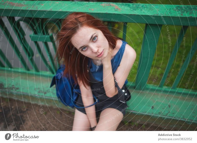 Millennial Frau ruht auf Brücke Zaun tausendjährig Hipster Jugendlicher rote Haare ruhen allein Stil urban Teenager Schüler Reisender Reling schäbig Lifestyle