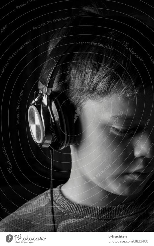 Kind mit Kopfhörer Musik Musik hören Porträt Lifestyle Schwarzweißfoto Junge genießen schwarzweiß
