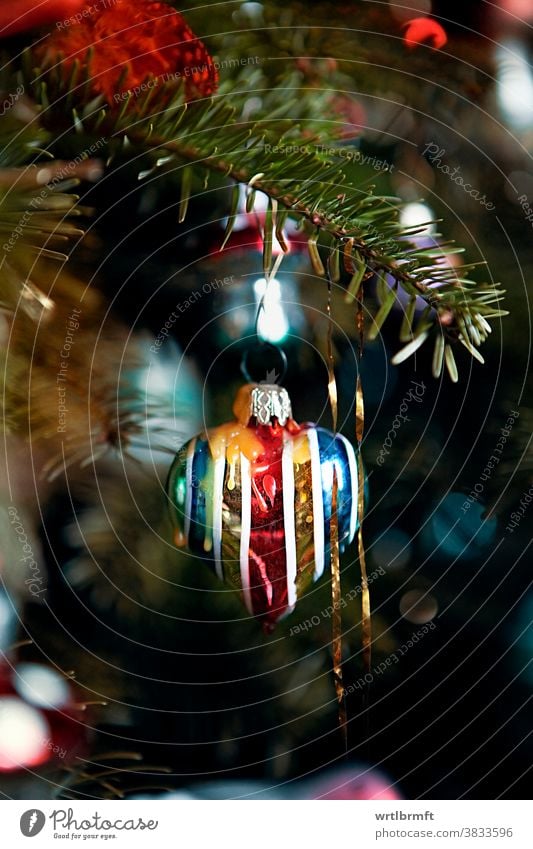 Ein Detail eines klassischen deutschen Weihnachtsbaums mit echten Kerzen und viel Lametta und einem herzförmigen Weihnachtsschmuck. Weihnachten Ornament