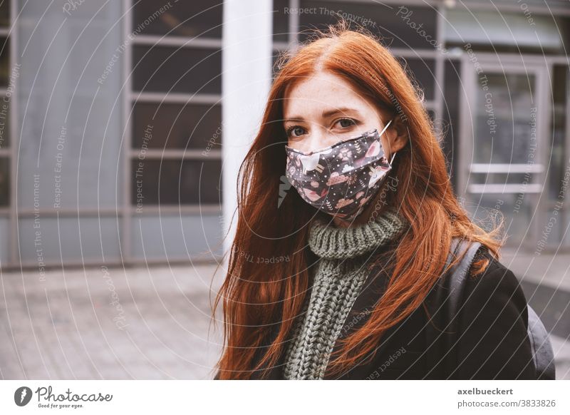 junge Frau, die in der Stadt draußen eine selbstgemachte Alltagsmaske trägt Stoffmaske Stoffgesichtsmaske Mund-Nasen-Bedeckung Corona Lifestyle Winter