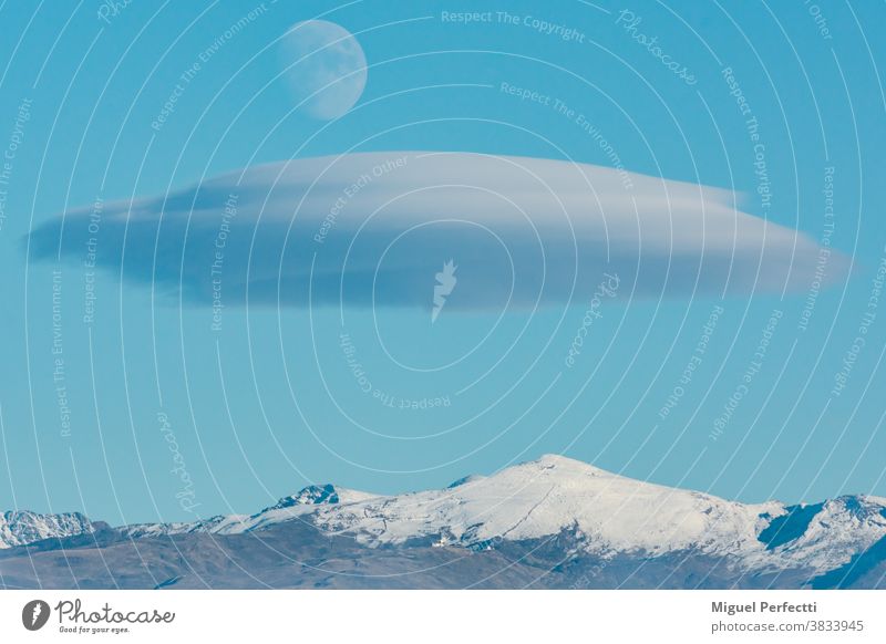 Landschaft der Sierra Nevada in Granada mit einer linsenförmigen Wolke und dem Mond über ihr. Veleta Gipfel Berge u. Gebirge Cloud Tourismus Schnee Skifahren