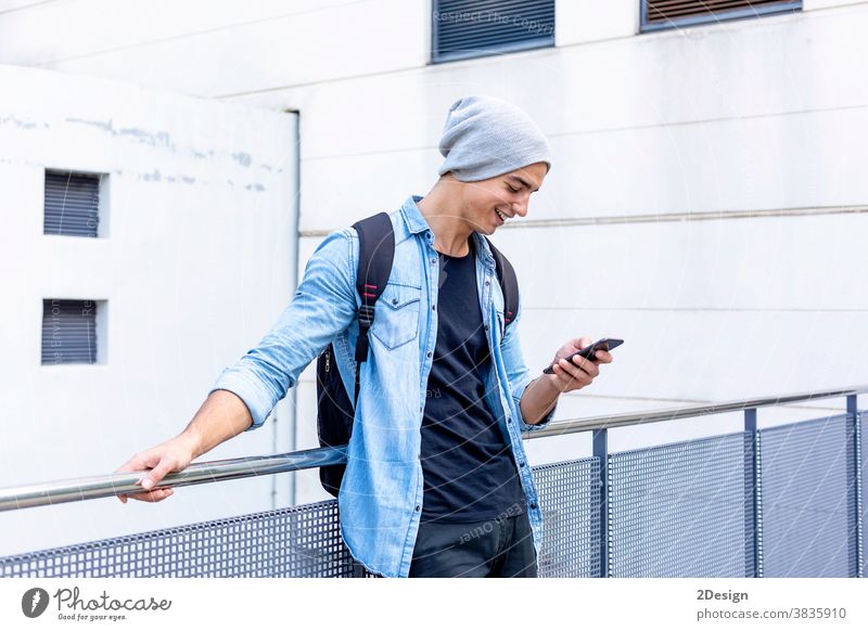 Städtischer stilvoller junger Mann, der mit seinem Handy an der Wand steht Stehen Telefon Smartphone sprechend Aufruf Typ Mobile männlich Technik & Technologie