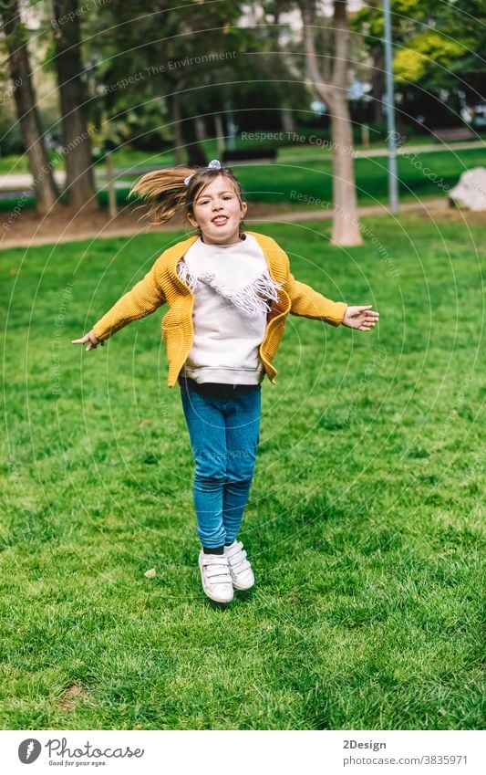 Hübsches kleines Mädchen springt an einem sonnigen Tag im Park über das Seil wenig springend im Freien 1 Glück Kindheit Fröhlichkeit spielen niedlich Spaß