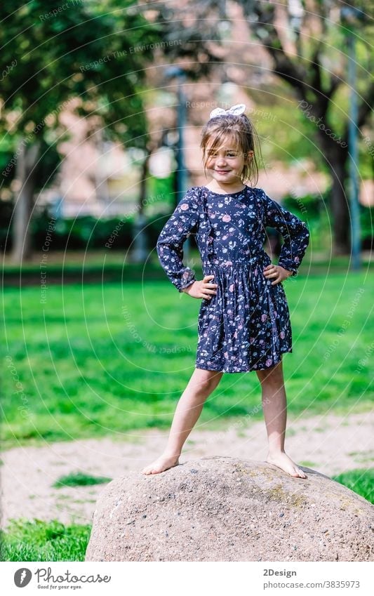 Porträt eines hübschen lächelnden kleinen Mädchens, das im Park im Freien steht. jung Lächeln bezaubernd Stehen Kind Kindheit heiter Person Kleinkind niedlich