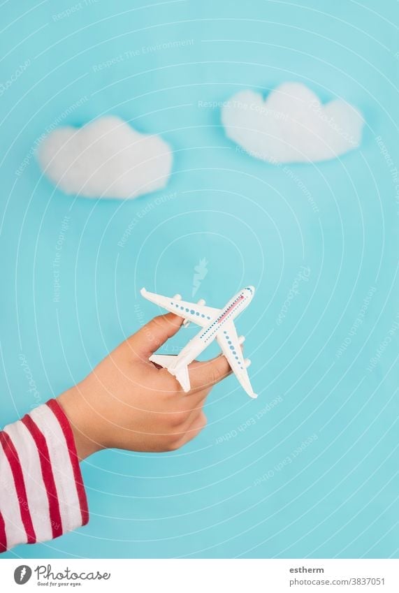 Kinderhände, die ein Spielzeugflugzeug über Wolken halten. Reise-Konzept Reisen erkunden Flieger Reisebüro Reisekonzept blau Ausflugsziel Reisender Lifestyle