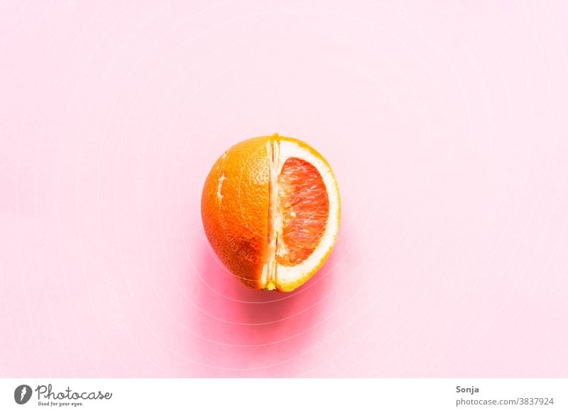 Eine aufgeschnittene Grapefruit auf einem rosa Hintergrund. roh Zitrusfrüchte Ernährung Farbfoto Gesunde Ernährung Bioprodukte Vegetarische Ernährung Gesundheit