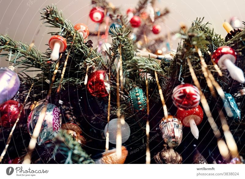 Ein Detail eines klassischen deutschen Weihnachtsbaums mit echten Kerzen und viel Lametta mit einer Vielzahl von Christbaumschmuck. Weihnachten Ornament