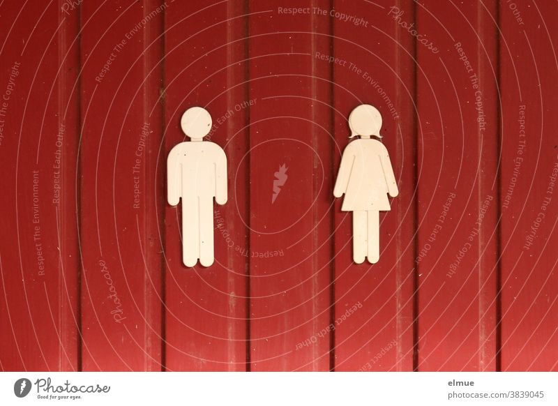 Weiße Piktogramme von Mann und Frau an einer roten Holztür Frau und Mann unisex Tür abstrakt Abstraktion Sinnbild Symbolik Schild Codes Bildsprache Bildzeichen