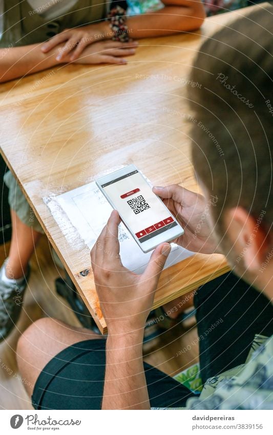 Mann scannt Restaurantmenü QR-Code qr-Code Speisekarte des Restaurants digital Mobile Abtastung Technik & Technologie Kunde Link Netz unkenntlich Information