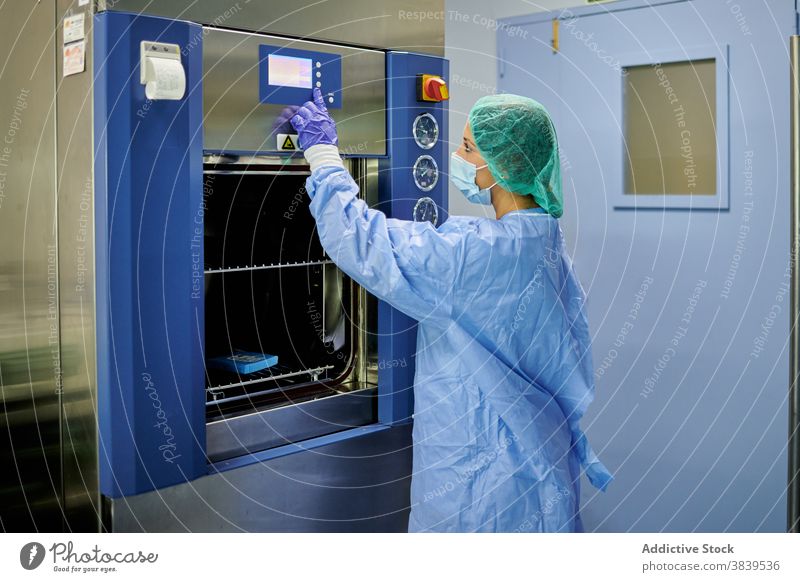 Weiblicher Arzt in Uniform mit Sterilisator Maschine Frau steril Arbeit medizinisch Kontrolle Krankenpfleger Krankenhaus Gerät modern Personal Beruf Klinik