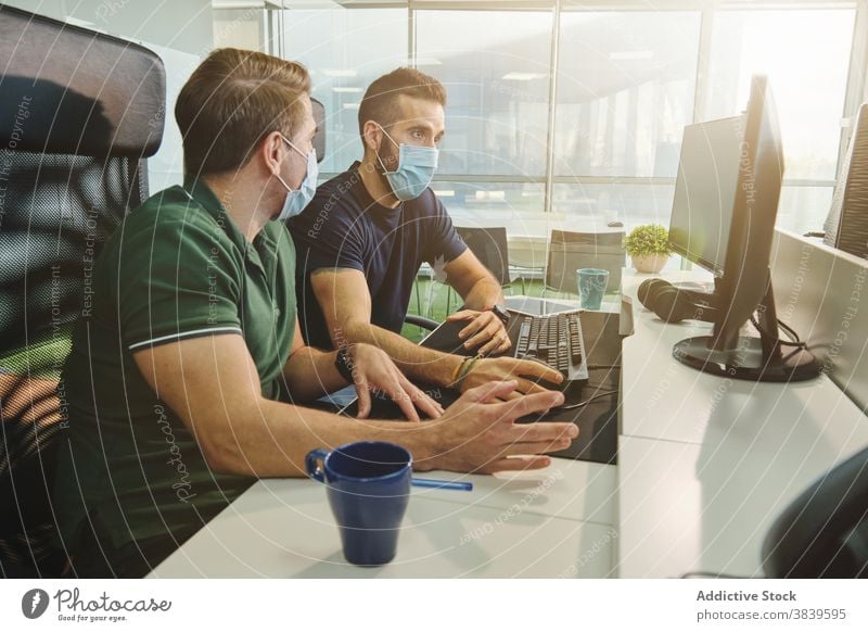 Männliche Software-Entwickler arbeiten gemeinsam im Büro programmieren Code Entwicklung Kollege Mitarbeiterin Programmierer Programmierung Coronavirus Pandemie