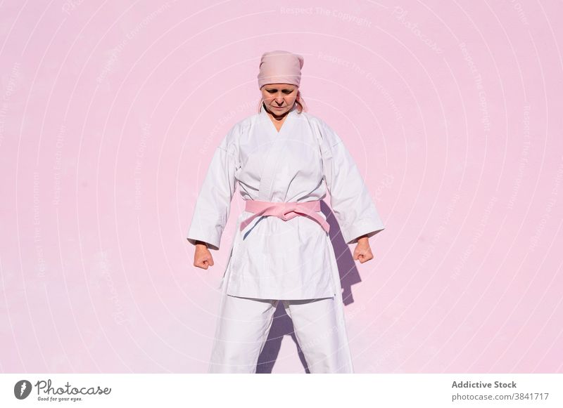 Karatefrau, die den Krebs besiegt hat Frau kämpferisch Kunst Sport Kampagne Erkenntnis Gesundheit Kämpfer rosa nachdenklich Foulard selbstbewusst Krankheit