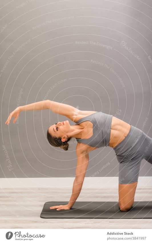 Frau übt Yoga zu Hause beweglich Asana Schiffsplanken Pose Seitenknick Unterlage Achtsamkeit ruhig sich auf die Hand lehnen Knie Gesundheit üben Harmonie passen
