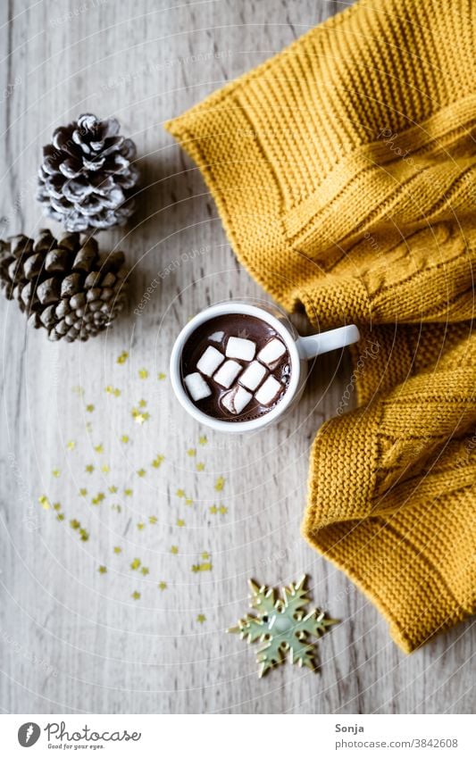 Heiße Schokolade mit Marshmellows, eine gelbe Wolldecke und goldene Sterne auf einem Holztisch. marshmellow Tasse Hygge rustikal Getränk süß Kakao Farbfoto