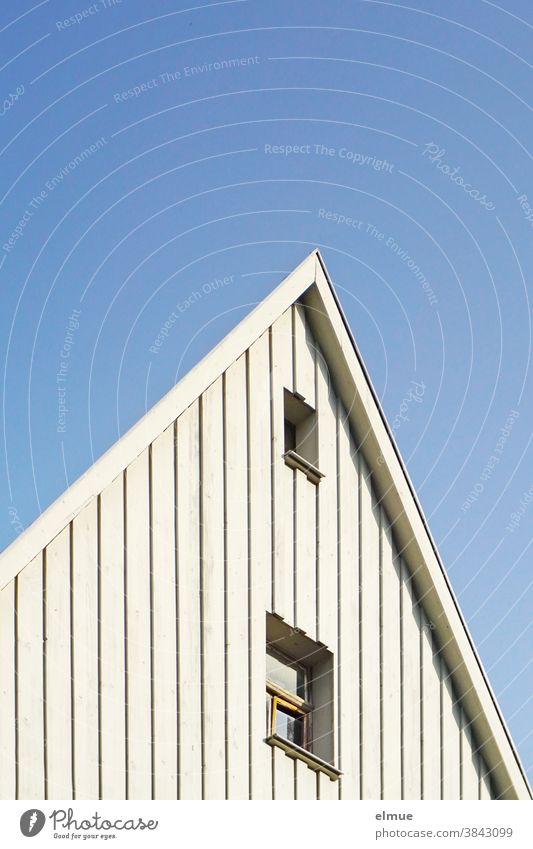 raffiniert gestalteter Hausgiebel in weißem Holz mit zwei Fenstern vor blauem Himmel / optische Täuschung Giebel wohnen Gebäude Fassade Wohnung Architektur