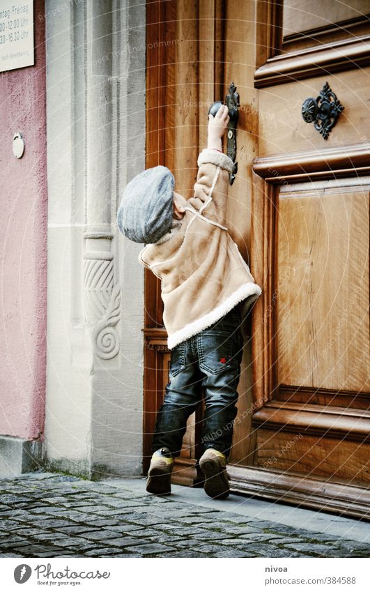 kleine hürden im alltag Kind Junge Kindheit Körper 1 Mensch 1-3 Jahre Kleinkind Altstadt Tor Mauer Wand Tür Griff Hose Jacke Mütze Stein Holz Metall berühren