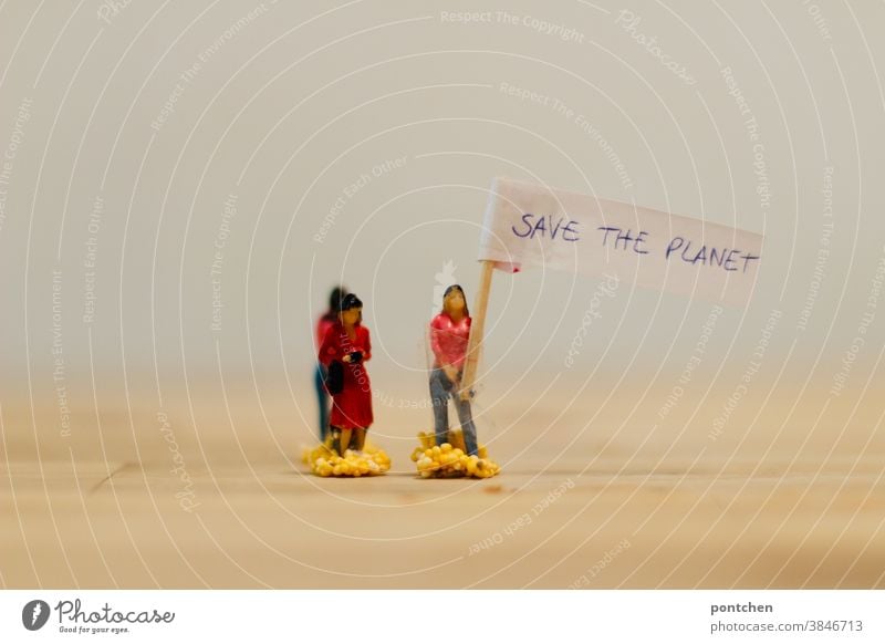 Demonstration. Frau hält ein Transparent hoch auf dem „Save the Planet“ steht. Klimawandel, Klimaschutz frauen figuren transparent schild klimaschutz