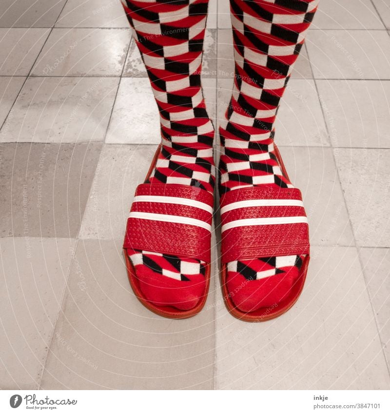 Gemusterte Socken in roten Badelatschen Farbfoto Nahaufnahme Vogelperspektive Fuß Füße Mode Stil geschmacklos aussergewöhnlcih anders hässlich gewagt weiß