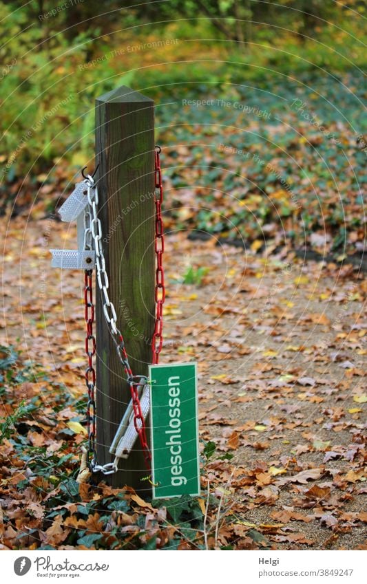 noch nicht  - Schild "geschlossen" hängt an einer rot-weißen Kette neben einem Holzpfahl, der Weg ist noch zugänglich Verbotsschild Hinweisschild Pfahl