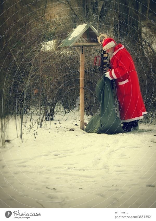 Der Weihnachtsmann ist gut zu Vögeln Sack Vogelhäuschen füttern Geschenke Schnee winterlich Weihnachten Vögel füttern weihnachtsmannmütze Weihnachtsmannmantel