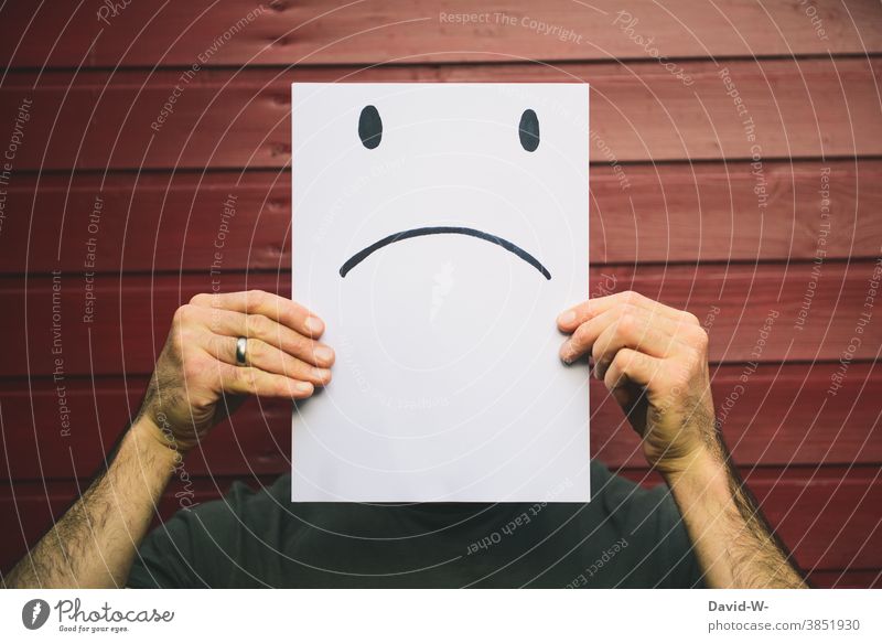 Mann mit trauriger Mimik aufgezeichnet - negativer smiley auf einem Zettel Gesicht Smiley Gesichtsausdruck böse Gefühle Emotionen verbittert Zeichung