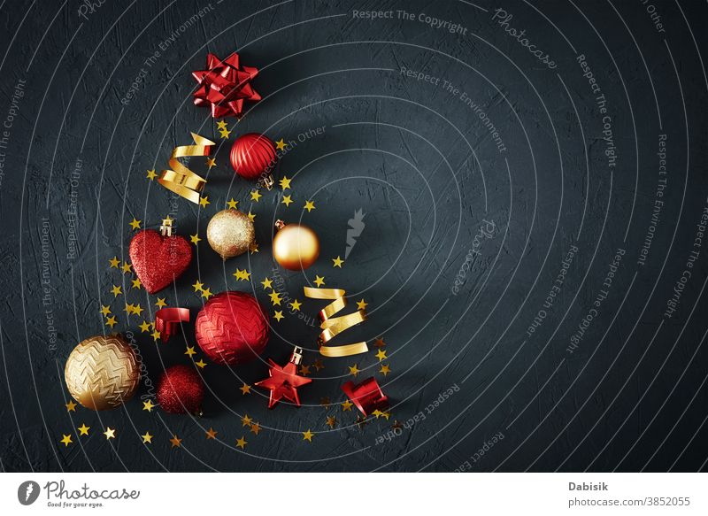 Weihnachtsbaum aus roten und goldenen Kugeln und festlichen Bändern auf dunklem Hintergrund mit Kopierfeld. Weihnachts-Konzept Weihnachten Baum