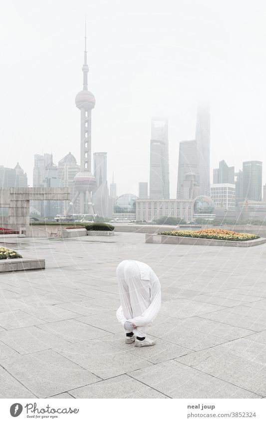 Yogapose vor der Skyline Shanghais Pose Vorbeuge akrobatisch China Sehenswürdigkeit Pu Dong menschenleer morgens neblig Stimmung Ruhe Harmonie Balance urban