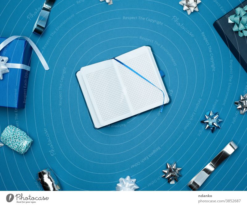 offenes Notizbuch mit leeren weißen Blättern, blauer Hintergrund mit Box Notizblock oben Jahrestag Geburtstag blanko Schleife Kasten Feier Weihnachten