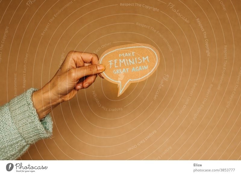 Hand hält eine Sprechblase auf der “Make feminism great again” steht. Feminismus, Emanzipation, Gleichberechtigung. Gleichstellung Gesellschaft (Soziologie)