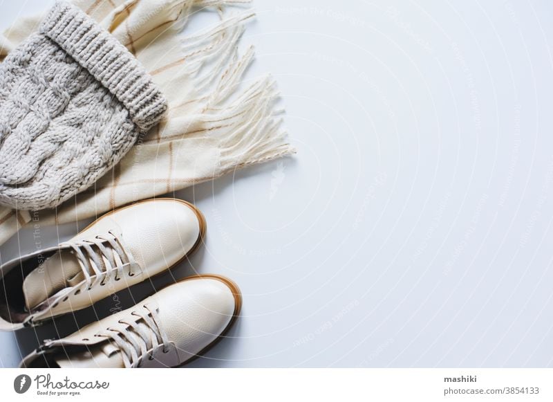 Wintermode-Set Draufsicht. Konzept des Online-Shoppings. Schuhe, Strickmütze und Schal in neutralen Beige-Tönen auf weißem Hintergrund Mode Kleidung Accessoire