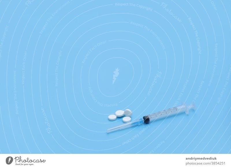 Spritze und weiße Pillen auf blauem Hintergrund. Platz für Ihren Text. Medizinischer Hintergrund. medizinisch Stethoskop Krankheit Gesundheit Kur Verschreibung