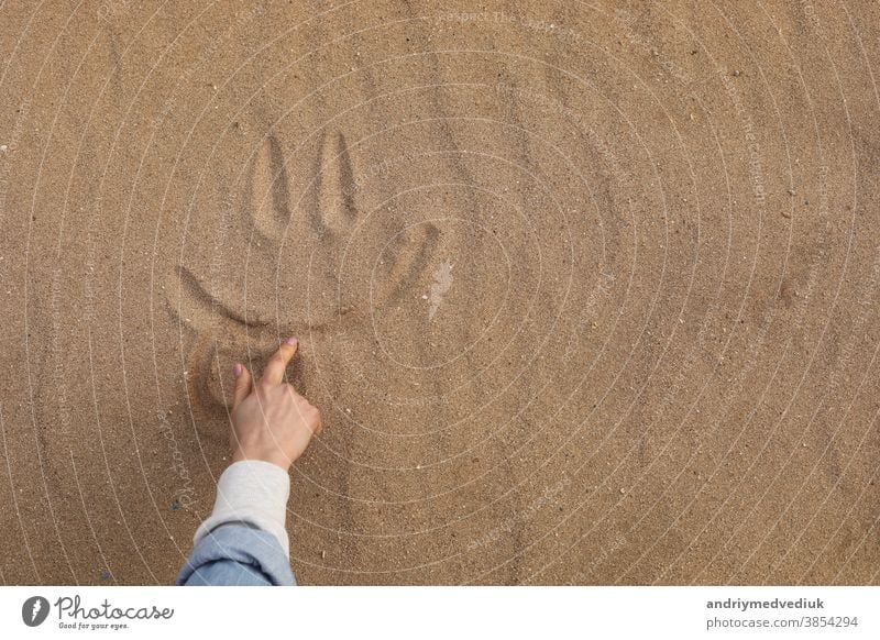 Ein schönes süßes Lächeln im Wüstensand von Hand zeichnen - Hintergrund Fuß Sand Feiertag Spaß Textur Gesicht Strand Symbol Sonne Freude Lifestyle sonniger Tag