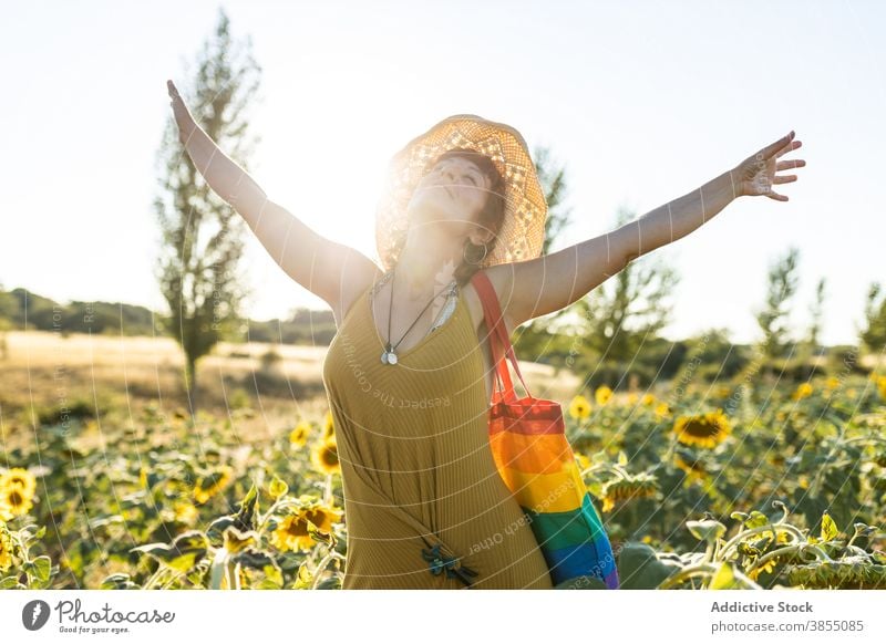 Frau entspannt im Sonnenblumenfeld Feld genießen Natur Blütezeit Blume Saison sonnig sorgenfrei Regenbogen Tasche stehen Windstille Wetter ruhig friedlich