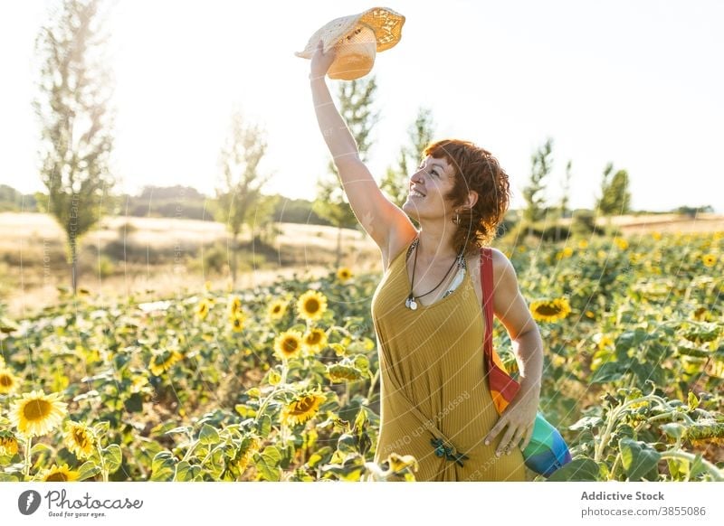 Ruhige Frau entspannt in Sonnenblumenfeld Feld genießen Natur Blütezeit Blume Saison sonnig sorgenfrei Regenbogen Tasche stehen Windstille Wetter ruhig