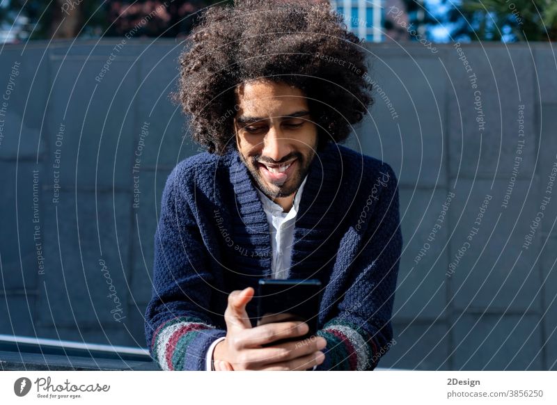 Lächelnder Afroamerikaner schreibt am Telefon SMS an Freunde. Mann 1 Afro-Look Mobile Glück männlich Technik & Technologie Handy Nachricht schwarz Typ