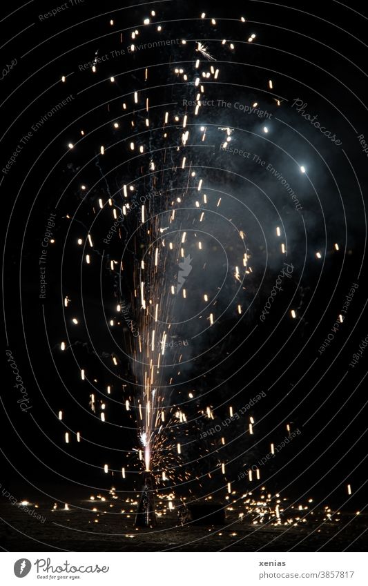 Eine Fontäne aus brennenden Funken leuchtet auf der Straße in der Nacht an Sylvester Feuerwerk Silvester u. Neujahr Explosion Pyrotechnik Feuerkegel