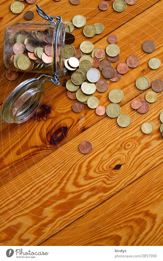 Kassensturz. Erspartes Kleingeld aus einem Einmachglas liegt ausgeschüttet auf einem Holzboden Ersparnisse Euro Münzen Armut Glas Eurocent Münzgeld Notgroschen