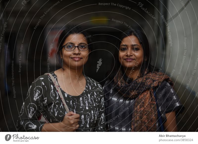 Porträt von zwei indisch-bengalischen brünetten Frauen/Freunden/Schwestern, die in einer Straße in einer Gasse in Bengalen stehen. Indischer Lebensstil