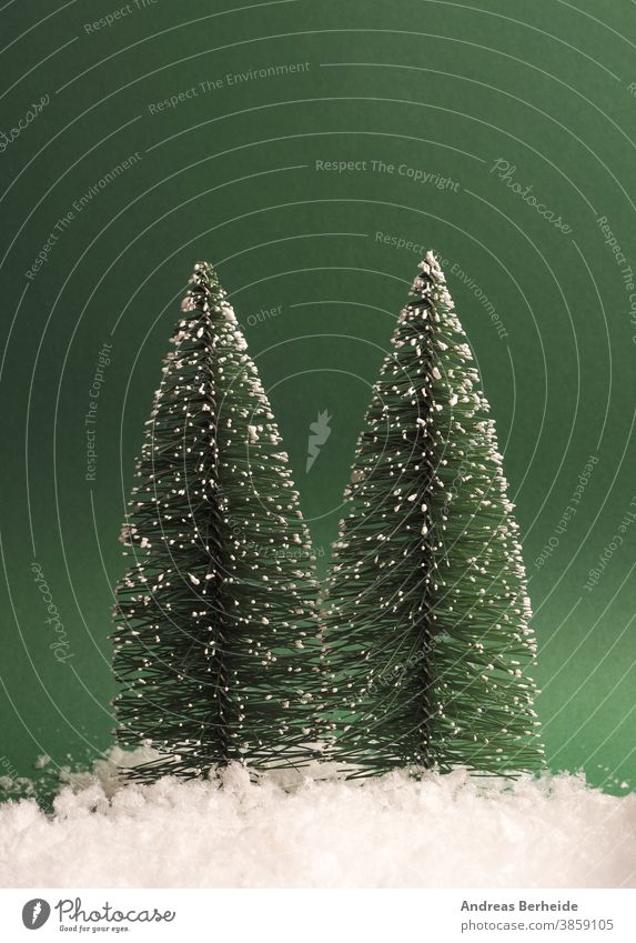 Zwei Tannenbäume mit Schnee auf grünem Papierhintergrund, oben Platz für Text Baum kreativ traditionell Schneeflocke sehr wenige trendy Gruß Textfreiraum